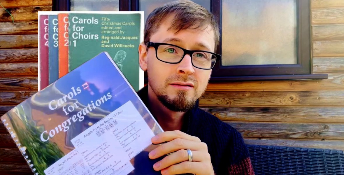 Ben Trigg holding a copy of Carols for Congregations